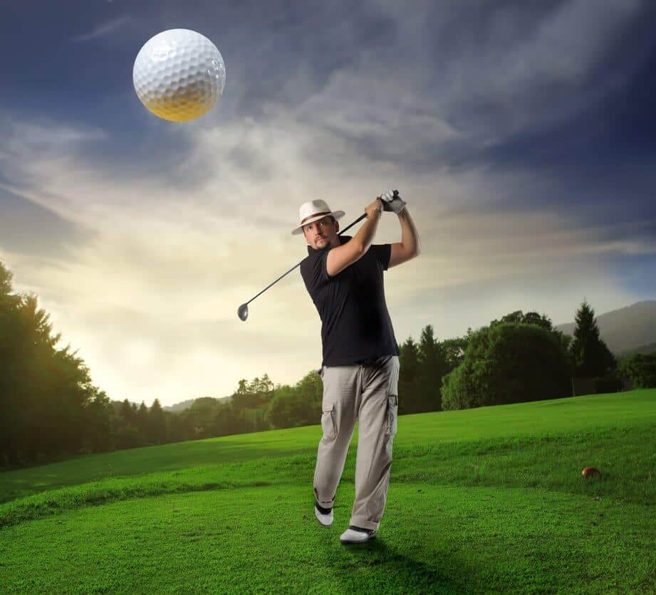A golfer swinging a golf club on a golf course with a flying golf ball in the image