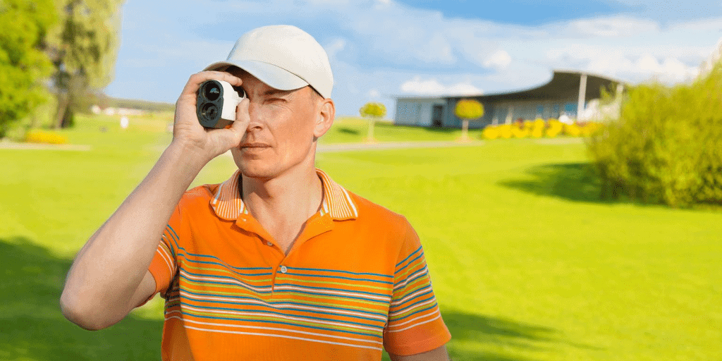 A golfer using a gold rangefinder on the golf course