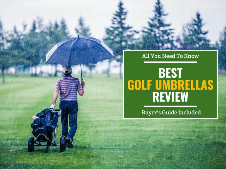 A golfer holding an umbrella in the rain while pulling his golf bad and cart on the golf course
