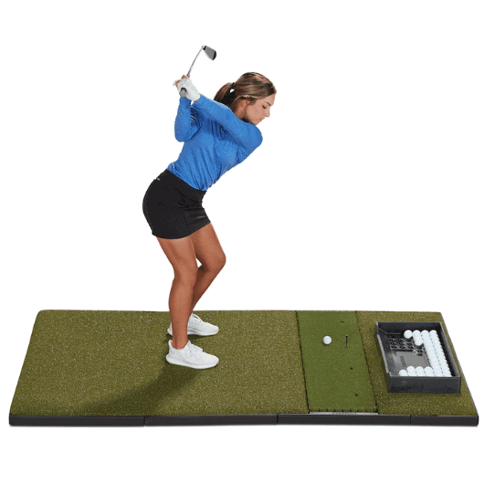 A female golfer practicing her swing on a Fiberbuilt 4 × 7 performance turf golf mat wiht a golf club, tee, and a bunch of golf balls on white background