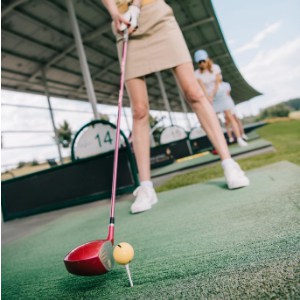 Female golfer preparing to make a shot in a golf driving range