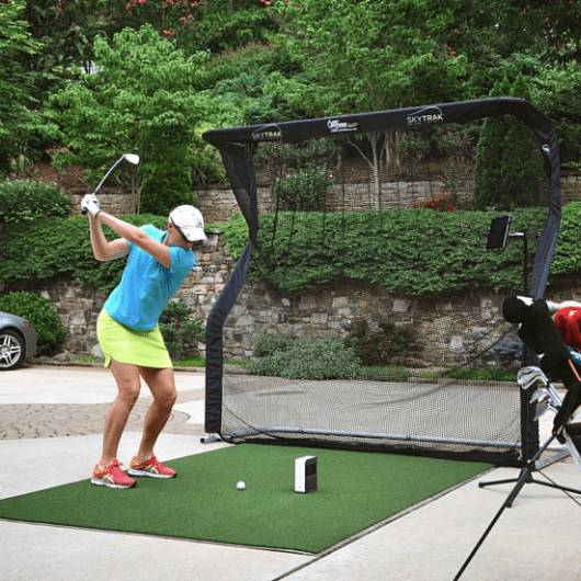Young lady using SkyTrak golf simulator training package outdoors