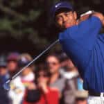 Tiger Woods following through a golf swing with a crowd watching behind