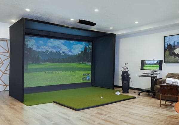 Uneekor eye xo launch monitor and golf simulator living room setup with golf clubs and golf balls in the area