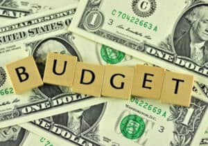 Image of scrabble letter pieces spelling out the word "budget" on top of dollar bills
