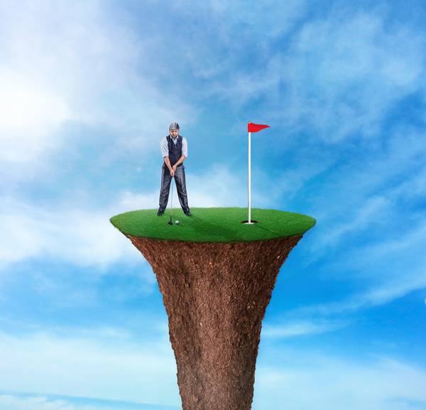 Edited image of a man on top of a golf course shaped in a tee trying to make a putting shot with sky background