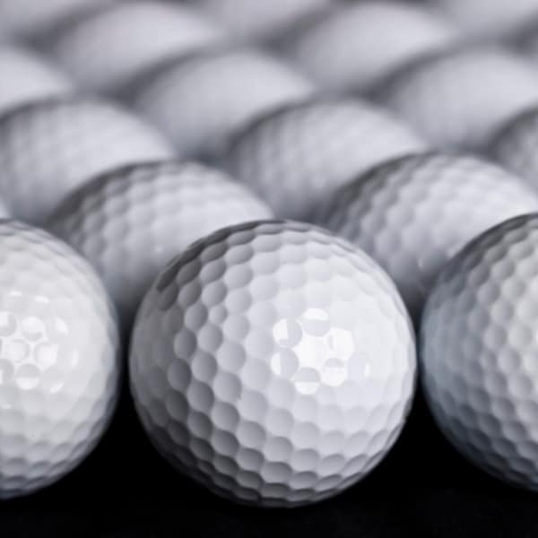 A bunch of golf balls featuring its dimples