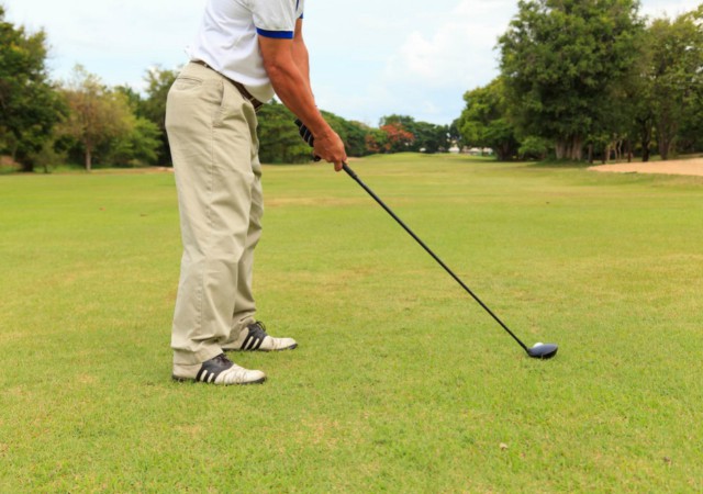 A man preparing to put a golf ball on a golf course