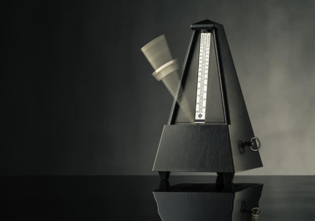 Image of a metronome on a black table and background