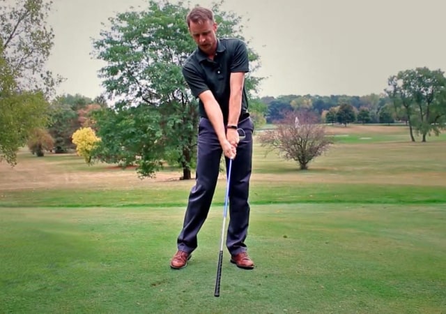 A man doing the swoosh drill with an inverted golf clubto practicing his golf swing