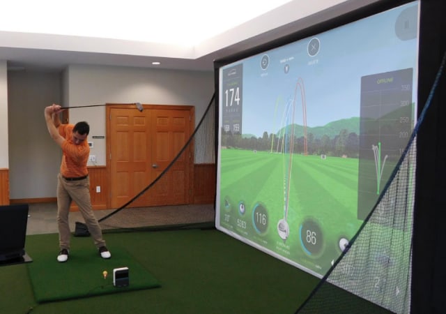 Microbay Screen Enclosure for Small Rooms set up with golfer using the golf simulator