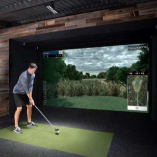 Full Swing Golf Simulator Package complete setup indoors with a golfer playing on the simulator