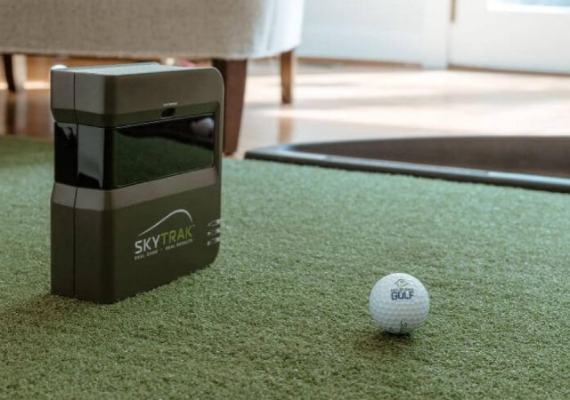 SkyTrak launch monitor on turf indoor with a golf ball in front of it