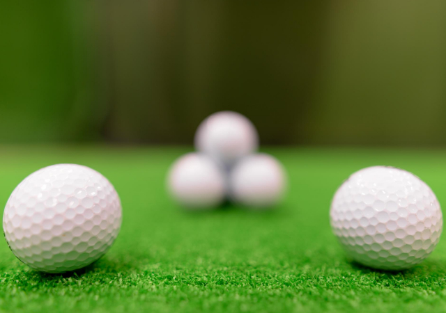 Five golf balls on turf