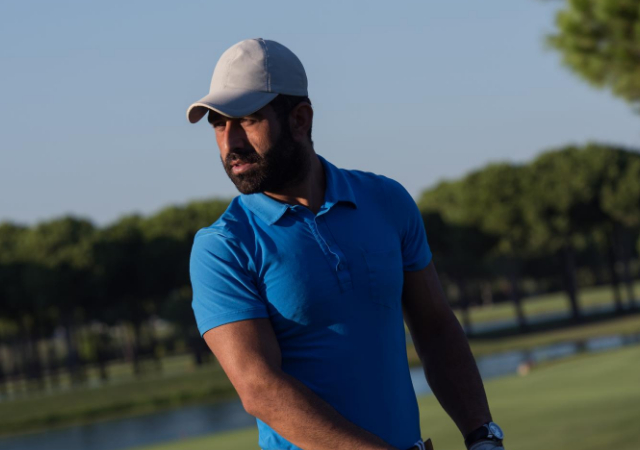 A golfer wearing a hat while looking into the distance