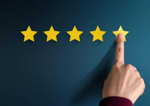 A hand pointing at the fifth star from the left indicating 5-star quality on blue background
