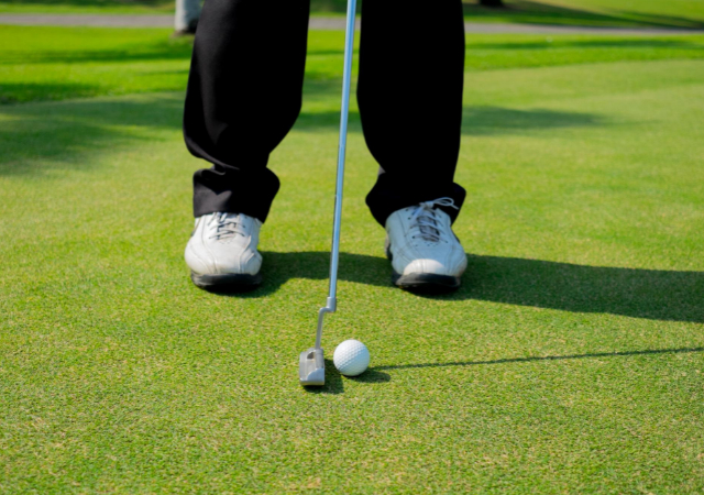 Golfer preparing to make a putt on a golf course