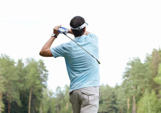 A golfer swinging his golf club on the golf course