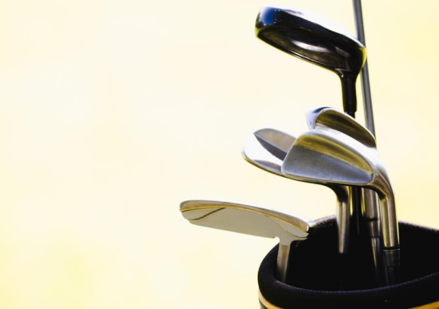 extra golf clubs in a golf bag on a yellow background