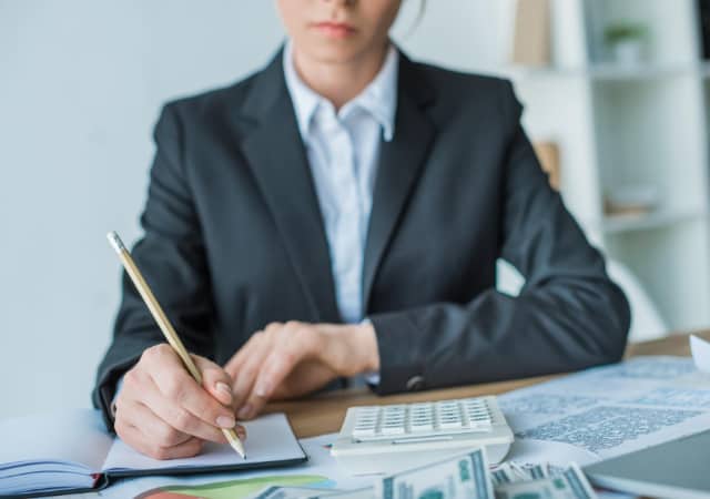 A financial assistant making computations on a table