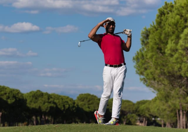 Golfer looking at his golf ball after completing a golf swing