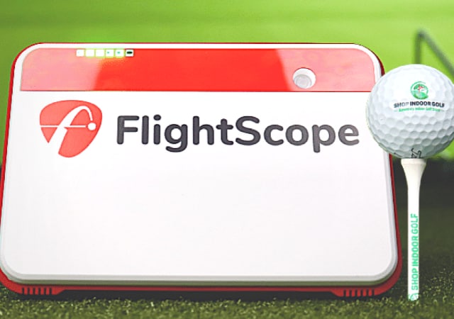 Flightscope Mevo Plus Launch Monitor beside a golf ball. 