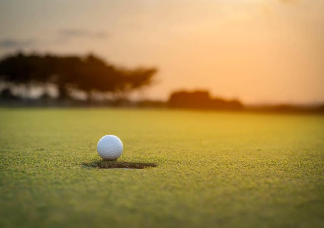 A golf ball near the hole. 